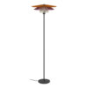 Tall black floor lamp with three stacked orange, purple, and cream shades atop a slender pole and round base, cord along the floor.