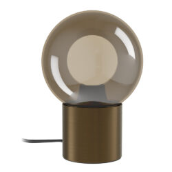 Bronze cylindrical base table lamp with a large clear glass globe and a cord trailing to the side.