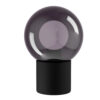 Purple glass sphere perched on a black cylindrical base, a modern decorative lamp.